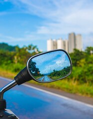 Motorcycle mirror reflecting highway and buildings