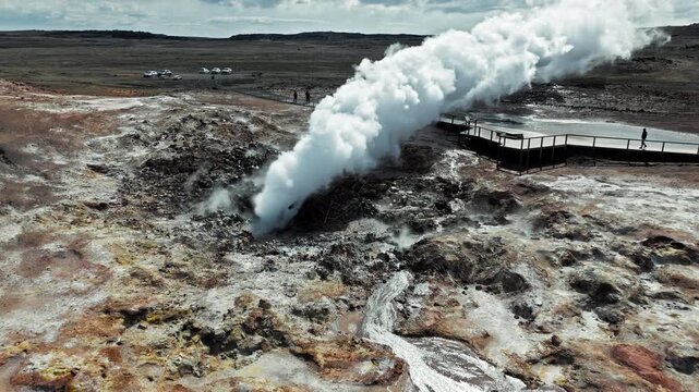 ide view of geothermal steam vent in Gunnuhver Reykjanes Iceland. Captured in 4K showing geothermal field with volcanic terrain and distant mountains.