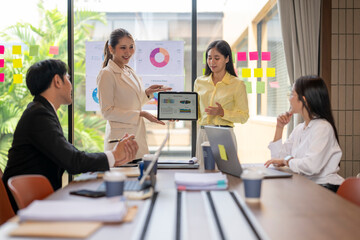 Businesswomen showing tablet with charts during office presentation meeting