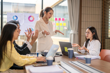Businesswoman leading meeting and discussing with her colleagues in office