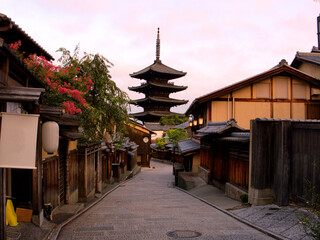 Naklejka premium ほんのりピンクに染まった朝焼けの空をバックに建つ、京都・清水寺近くの有名な観光スポットの八坂の塔（法観寺）