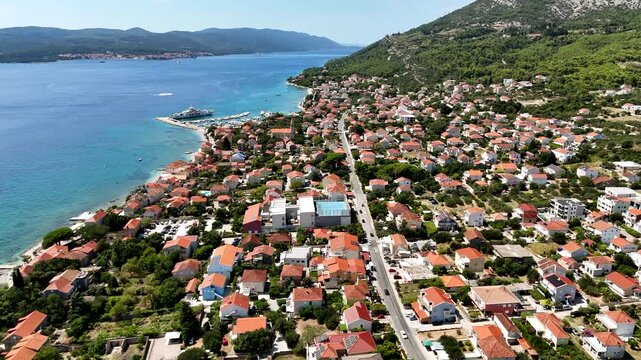 Aerial view of a beautiful blue ocean with a small town on the shore.