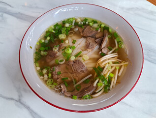 Pho is a typical Vietnamese beef broth dish served with white noodles, fresh vegetables, and sliced meat.