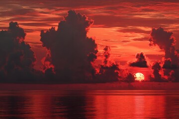 Fiery sunset over a calm sea, dark clouds