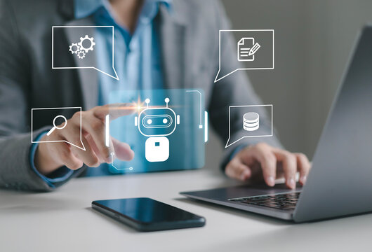 Businessman using laptop to control AI at desk in office. Artificial intelligence is analyzing data and generating reports. Artificial intelligence and intelligent automation (IA) technology.