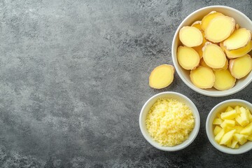 Freshly Chopped Ginger and Apples Arranged Neatly on a Dark Textured Surface Displaying Natural Ingredients for Cooking or Healthy Recipes