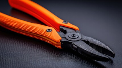 Close-up macro shot of orange handled pliers and wrench with textured grip, industrial product photography