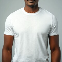 Fototapeta premium A Black man in a plain white t shirt stands against a neutral background. The blank shirt is ideal for clothing mockup and fashion display.