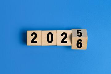 flip wooden blocks with year 2025 to 2026 isolated on blue background