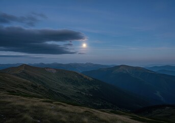 Night landscape of the carpathian mountains with the moon shining through the clouds in the blue sky
