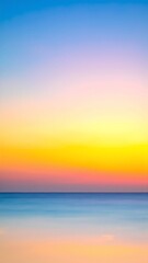 Obraz premium A vibrant sunset paints the sky in hues of orange, pink, and purple, reflecting on the calm ocean waves beneath a deep blue sky.
