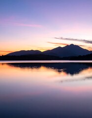 Fototapeta premium Calm lake reflects colorful sunset over mountains