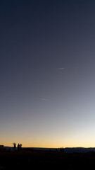 Minimalist sunset sky with two contrails and tiny silhouettes