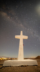 Milky Way galaxy shining over a white cross in the Atacama Desert