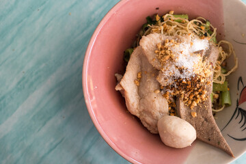 A Thai dish of yellow noodles topped with minced pork, peanuts crispy pork rinds and fish balls A popular choice in Thailand seen from above