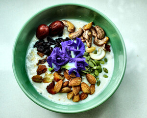 Plant-based oatmeal breakfast with nuts, seeds, and butterfly pea flowers – healthy food for gut health, microbiome balance, and wellness lifestyle