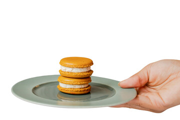 Delicate Macarons on a Plate: Exquisite stack of two golden-hued macarons, filled with a creamy,...
