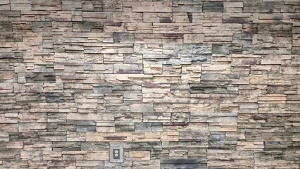 Faux Stone Wall Clad With Stacked Field Stones Contemporary Architecture Professional Building Modern Interior Design Accent Wall Rock Surface Beige and Grey Natural Stone Veneer Installation 