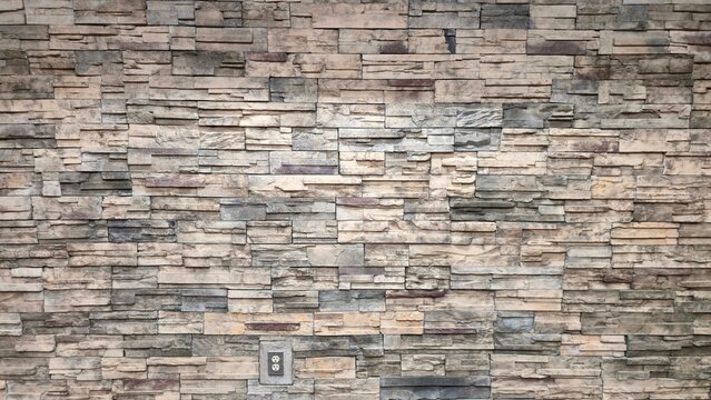 Faux Stone Wall Clad With Stacked Field Stones Contemporary Architecture Professional Building Modern Interior Design Accent Wall Rock Surface Beige and Grey Natural Stone Veneer Installation 
