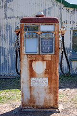 Old petrol fuel bowser outside historic garage and auto mechanic