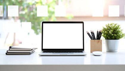 Laptop on workspace desk with stationery and plant