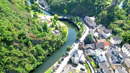 Esch-sur-Sure, Wiltz, Grand-Duche de Luxembourg, August 10, 2025, Stunning aerial photography beautifully captures a serene riverbend, enriched with lush greenery and charming buildings