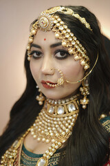 Elegant Indian bride wearing a traditional red embroidered bridal lehenga with intricate jewelry, bangles, and bridal makeup