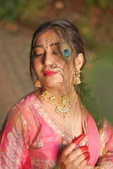 Close-up portrait of an elegant Indian woman dressed in a traditional pink saree, adorned with...