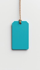 Hanging turquoise tag on string against a plain white background providing copy space for your message and promotions