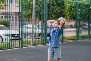 A teenage boy throws a ball into a basketball hoop at a sports field. Active games. Sports. Generation