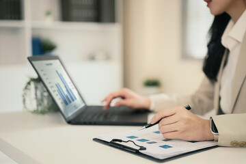 Professional woman reviewing data and strategy documents at modern office desk