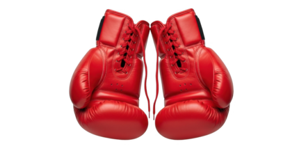 A pair of bright red boxing gloves hanging against a stark black background ready for a fight or training session for a strong opponent