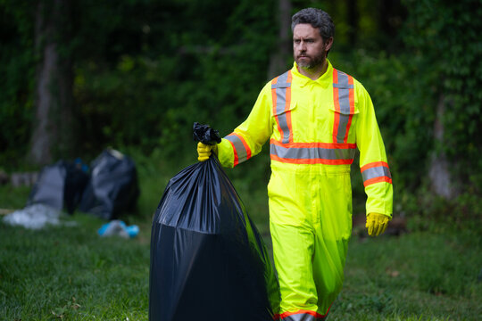 Volunteer man collecting garbage, picking up waste at nature. Land pollution, environmental problem. Landfill a pile of plastic garbage. Pollution of nature. Ecology concept. Pollution environmental.