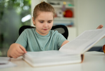 Child reading book at home. Kid book studying. Child opening book indoors. Little kid learning with...