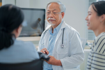 Asian daughter accompanies senior mother for medical consultation with doctor using digital health...