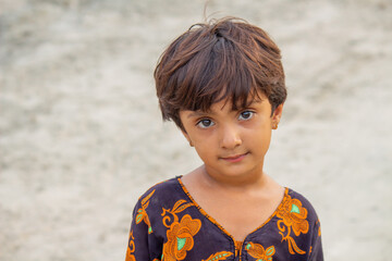 Little poor girl with innocent expression in refugee camp, symbolizing poverty, abandoned childhood, and survival