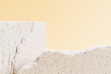 Empty stone podium against a beige wall background, ideal for mockups and showcasing cosmetic...