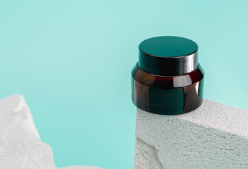 Cosmetic bottles on a stone podium, Blank label package for mock up on a blue background. The...