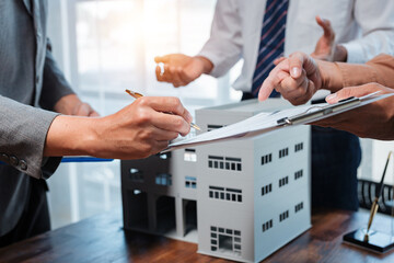 Businessmen signing contract for new industrial building, discussing terms and conditions of...