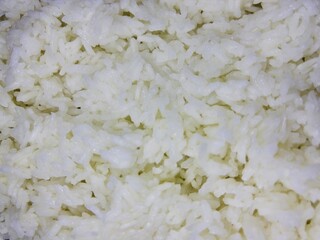 macro shot of steamed white rice, capturing the soft texture and subtle reflections on each individual grain, highlighting its fresh and fluffy appearance.