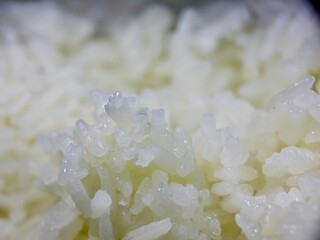 macro shot of steamed white rice, capturing the soft texture and subtle reflections on each...