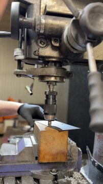 Industrial drill press machine countersinking holes on metal plates. Precision machining process in a factory environment. Concept of metalwork and production.