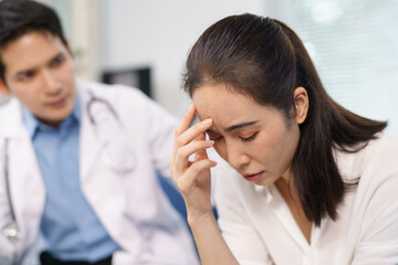 Doctor comforting a sad patient experiencing a headache in the hospital, providing support and...