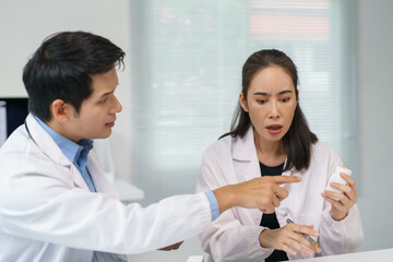 Two worried doctors discussing about a medicine bottle, having a doubt about its content or...