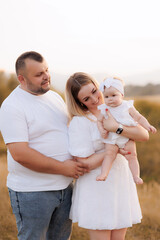 Fototapeta premium Loving family enjoying a peaceful sunset in a serene field setting