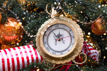 Golden retro clock on a decorated Christmas tree 2026. A beautiful background for New Year's Eve or...