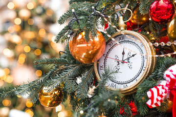 Golden retro clock on a decorated Christmas tree 2026. A beautiful background for New Year's Eve or...