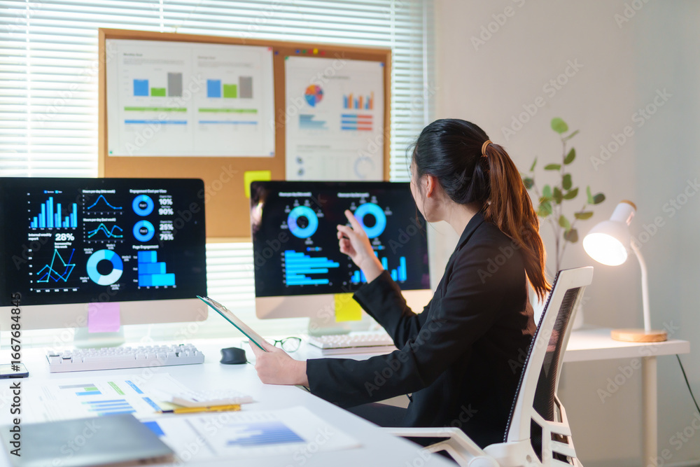 Poster businesswoman pointing at computer screen showing graphs, analyzing financial data and statistics fo