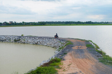 People riding motorcycles enjoying the riverside atmosphere.