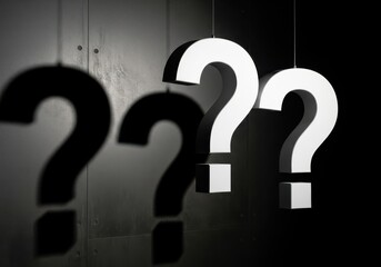 Three large white question marks hanging in front of a dark background